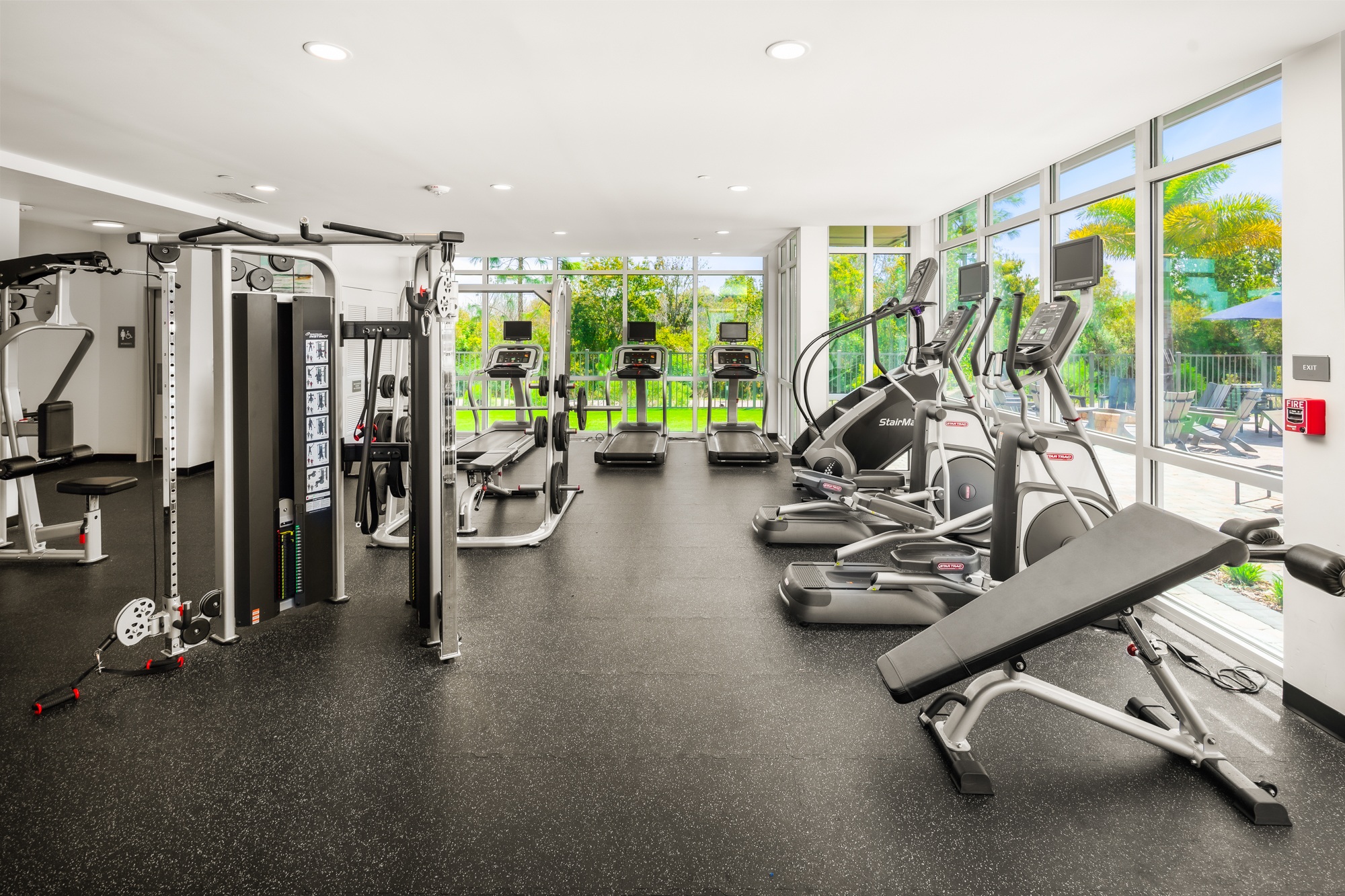 A gym with a variety of equipment including treadmills, weights, and exercise machines.